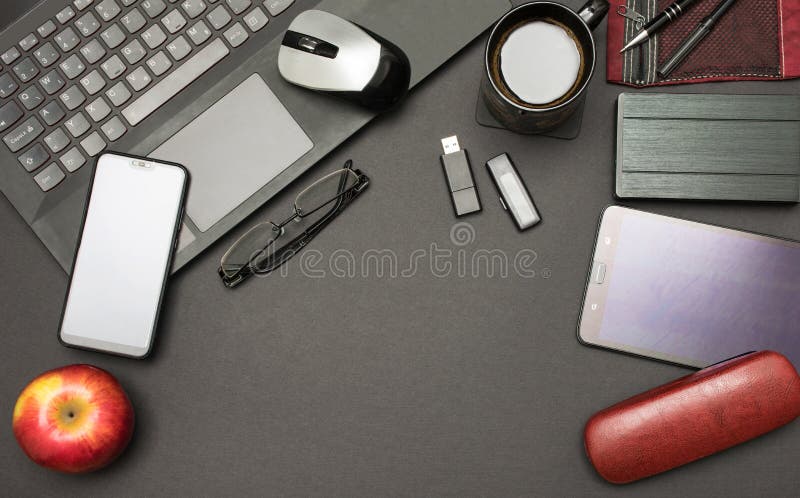 Stół biurowy z czarnym widokiem na górę i dostawami w tle, laptop, filiżanka kawy, czerwone jabłko, usb, dysk, tablet, okulary zdjęcia royalty free Stół biurowy z czarnym widokiem na górę i dostawami w tle, laptop, filiżanka kawy, czerwone jabłko, usb, dysk, tablet, okulary zdjęcia royalty free