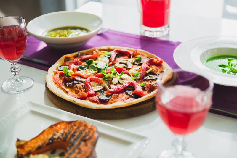 Stół w kawiarni z jarskimi naczyniami pizza, napoje -, piec na grillu bani, kulebiaka i cukierki, zdjęcie royalty free Stół w kawiarni z jarskimi naczyniami pizza, napoje -, piec na grillu bani, kulebiaka i cukierki, zdjęcie royalty free