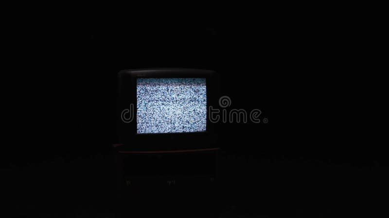 Störgeräusch auf dem alten Fernsehschirm in der Dunkelheit ablage Ein Elektrogerät mit Störung auf schwarzem Hintergrund