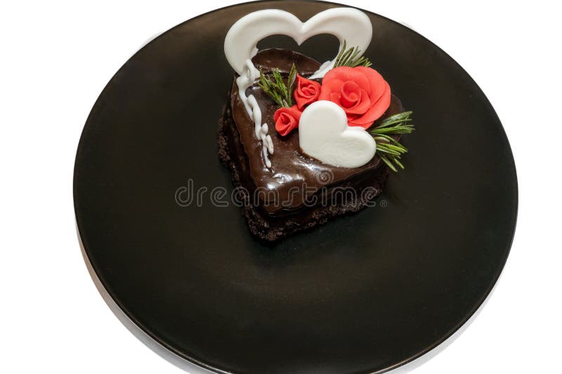 Stück romantischer Schokoladenkuchen auf schwarzer Platte. kleine gebackene Kuchen dekoriert für heilige Valentinstag mit Liebe un stockfoto