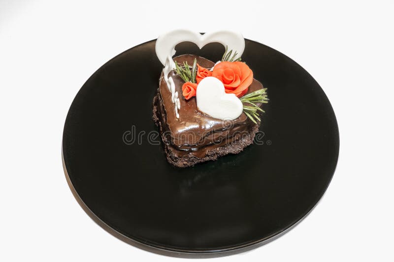 Stück romantischer Schokoladenkuchen auf schwarzer Platte. kleine gebackene Kuchen dekoriert für heilige Valentinstag mit Liebe un lizenzfreie stockbilder