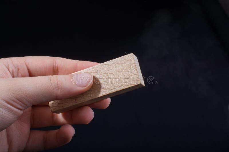 Stückchen geschnittenes Holz in der Hand