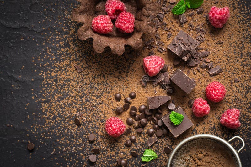 Stücke Schokolade, frische Himbeeren und Tartlets vorbereitung Lebensmittelnachtischhintergrund lizenzfreies stockbild Stücke Schokolade, frische Himbeeren und Tartlets vorbereitung Lebensmittelnachtischhintergrund lizenzfreies stockbild