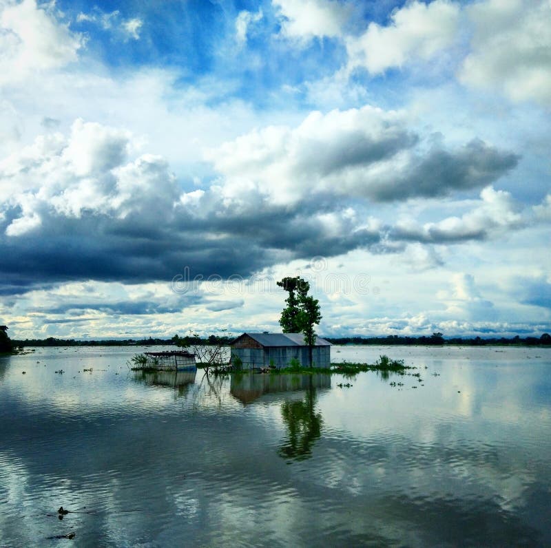 Submerged house in flood waters in a cloudy day