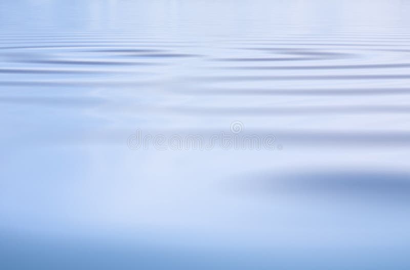 Una superficie d'acqua di sfondo con dolci ondulazioni e i riflessi della luce.