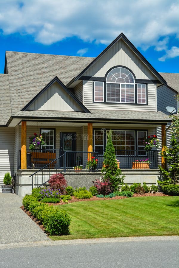 Suburban house with landscaping in front and blue sky background. stock image