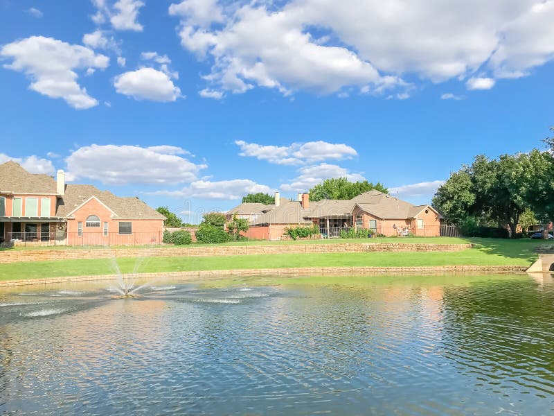 Suburban Lakefront Houses with Water Fountain and Green Grass Lawn Near ...