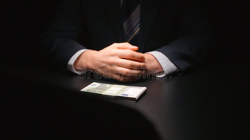 SUBÔRNO: O homem de negócios espera e põe um dinheiro sobre um EURO da tabela - de duas pessoas imagens de stock SUBÔRNO: O homem de negócios espera e põe um dinheiro sobre um EURO da tabela - de duas pessoas imagens de stock