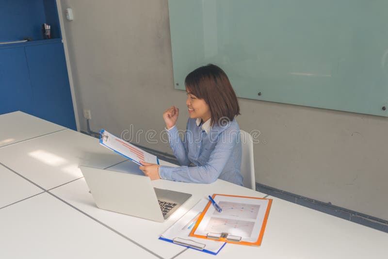 Succesful Asian businesswoman reading financial reports and feel happy stock photo Succesful Asian businesswoman reading financial reports and feel happy stock photo