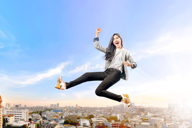 Successful asian business woman jumping high stock image Successful asian business woman jumping high stock image