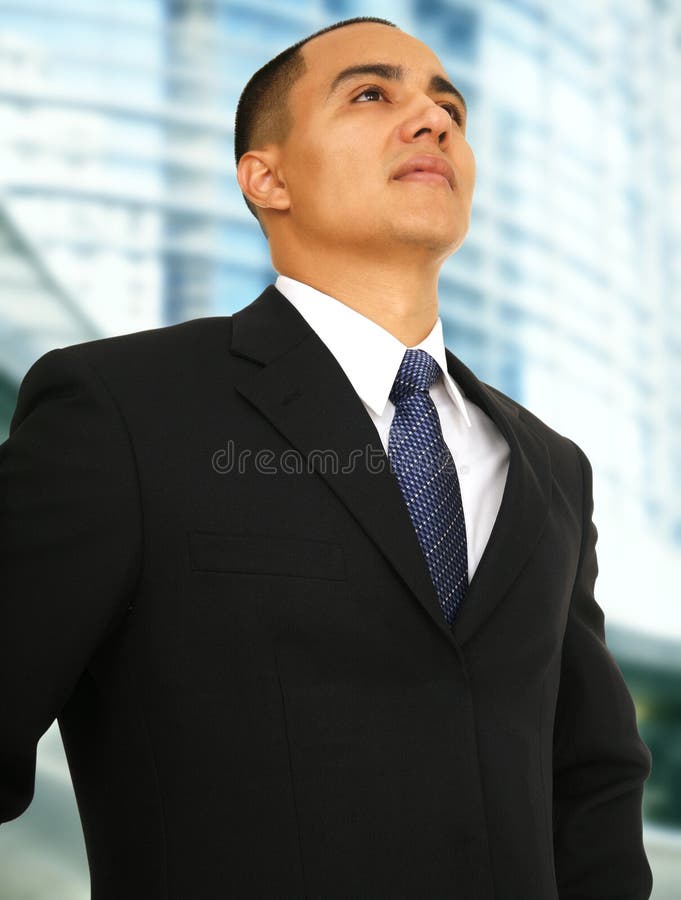 Successful business man standing and looking up with abstract building background