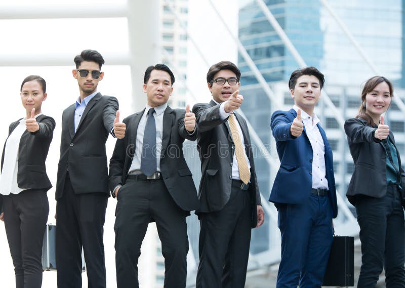 Successful business people with thumbs up and smiling stock photography Successful business people with thumbs up and smiling stock photography