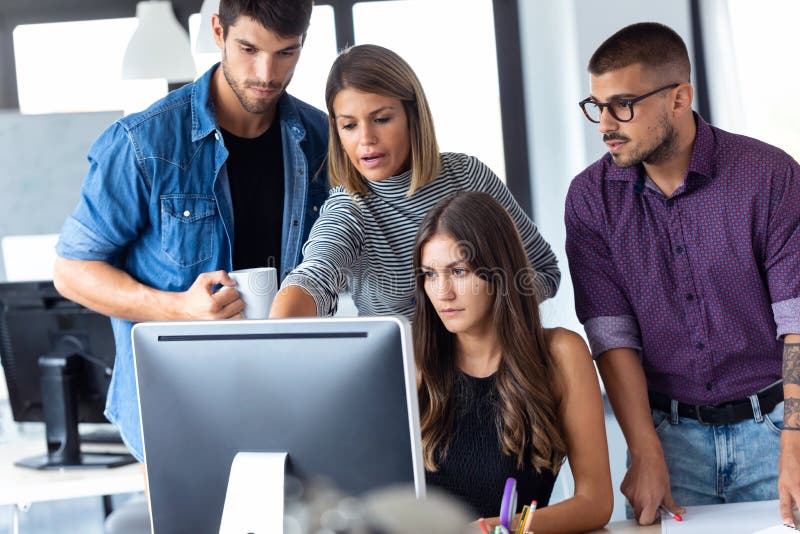 Shot of successful business team standing around computer for presentation of work in the coworking space. Computer editing stock images, royalty-free photos and pictures
