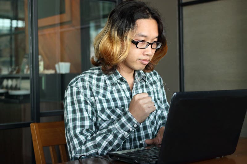 Successful and confident young Asian hipster with casual clothes working with laptop for his job in workplace of office. stock photos Successful and confident young Asian hipster with casual clothes working with laptop for his job in workplace of office. stock photos