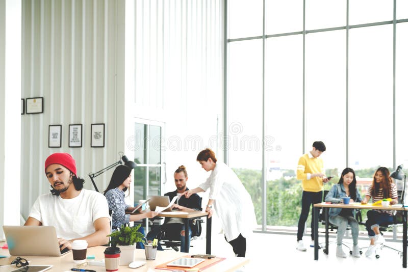 Successful multiethnic business team in routine work creative lifestyle standing, sitting and talking together at modern office wi stock photo Successful multiethnic business team in routine work creative lifestyle standing, sitting and talking together at modern office wi stock photo