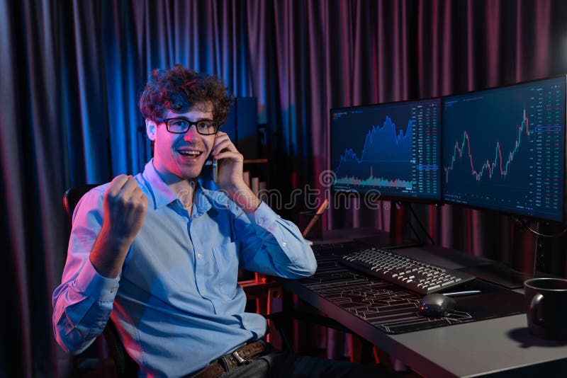 Successful young business trader raising fist up with highest profit stock with looking at camera in real time market data graph at neon office, calling to broker earning valued rate upper. Gusher. Successful young business trader raising fist up with highest profit stock with looking at camera in real time market data graph at neon office, calling to broker earning valued rate upper. Gusher.