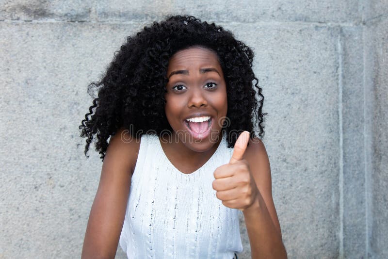 Successful african american woman with curly black hair showing thumb up. Successful african american woman with curly black hair showing thumb up