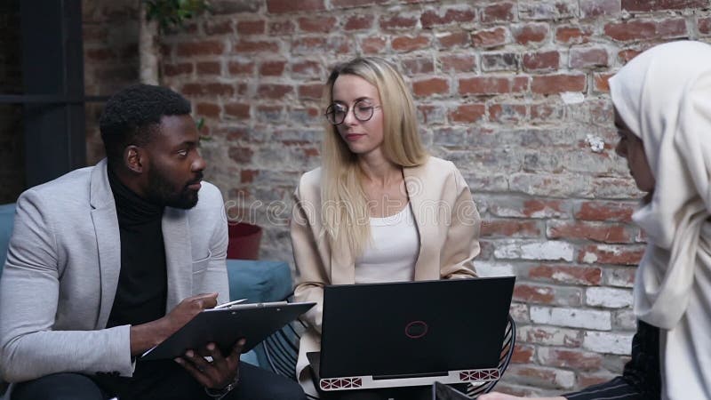 Succesvolle jonge zakelijke vrouwtjes brainstorming met hun zakelijke teamcollega's maakt gebruik van een laptop die nieuwe ideeë
