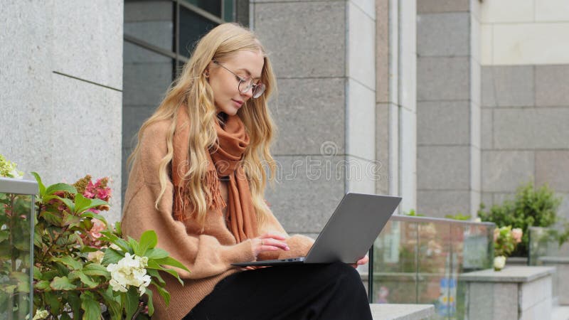 Succesvolle zakenvrouw die werkt op een laptop in de stad caucasian girl student die buitenshuis vertrekt , typt een dame