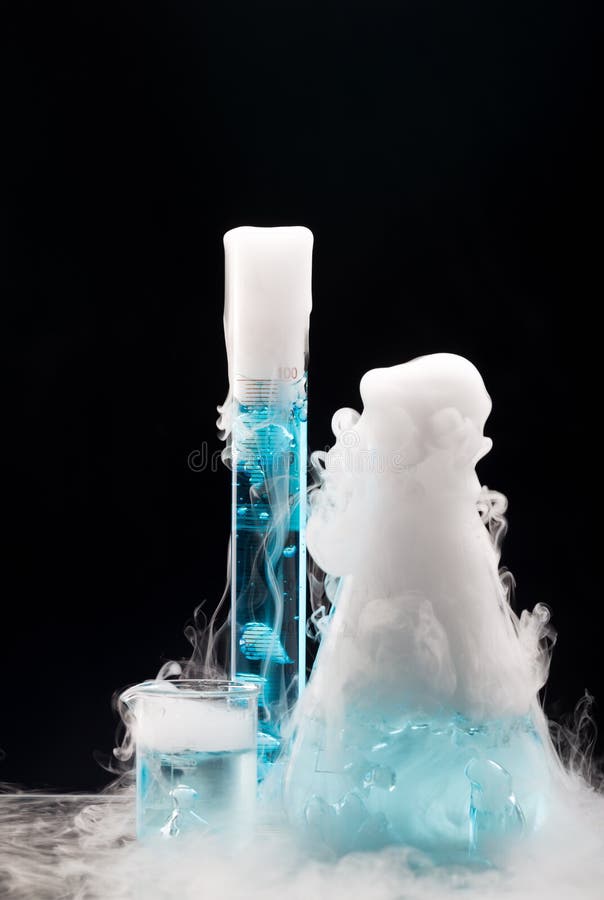 Dry ice in flasks with blue liquid. Black background. Sublimation of dry ice. Experiment in the laboratory. Dry ice in flasks with blue liquid. Black background. Sublimation of dry ice. Experiment in the laboratory.