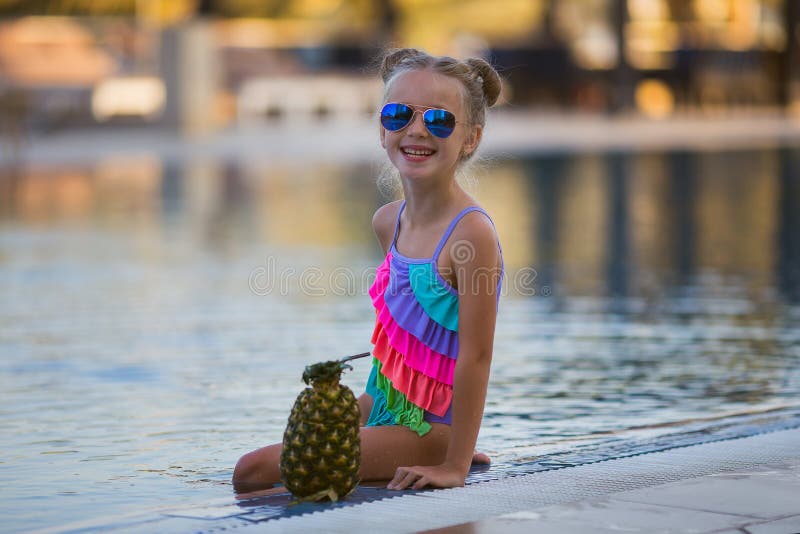 Suco bebendo da criança na barra da piscina imagem de stock Suco bebendo da criança na barra da piscina imagem de stock