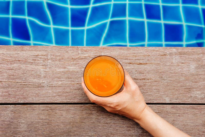Suco de fruta do verão Mulher que relaxa na piscina em seu V imagens de stock Suco de fruta do verão Mulher que relaxa na piscina em seu V imagens de stock