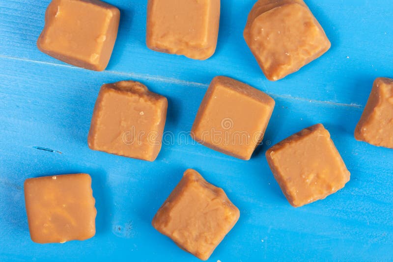 Sucreries de caramel de Brown sur les conseils en bois bleus images libres de droits Sucreries de caramel de Brown sur les conseils en bois bleus images libres de droits