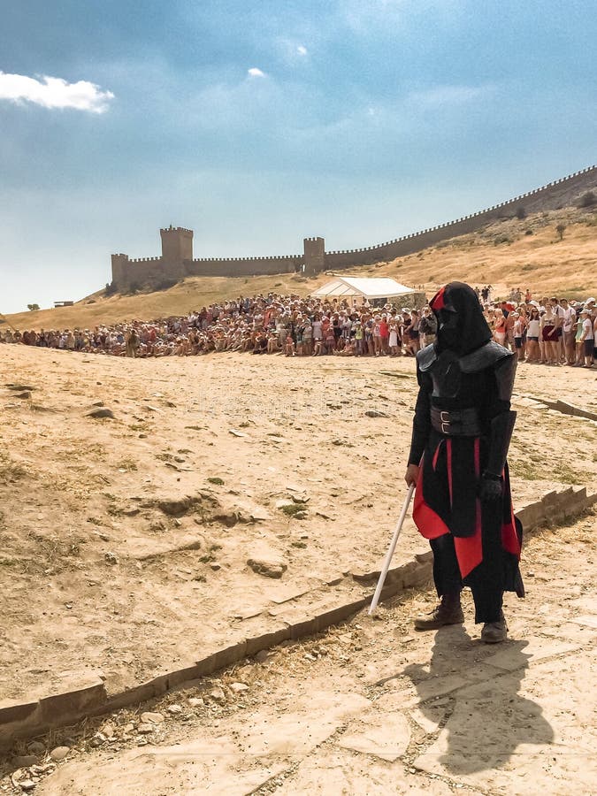 Sudak, Rusia - 16 de agosto de 2015: Carácter Darth Vader de la saga de Star Wars con la espada en su mano contra la perspectiva imágenes de archivo libres de regalías Sudak, Rusia - 16 de agosto de 2015: Carácter Darth Vader de la saga de Star Wars con la espada en su mano contra la perspectiva imágenes de archivo libres de regalías
