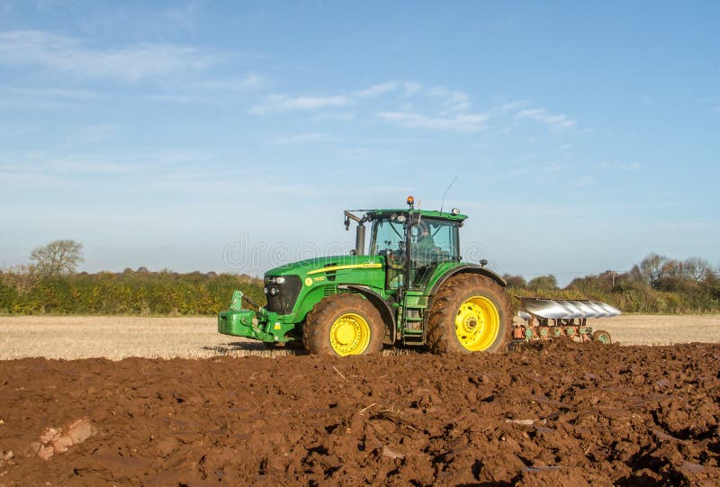 Modern John Deere tractor pulling a plough