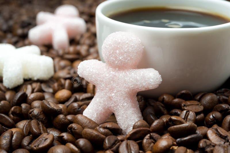 Sugar in the form of a little man and a cup of coffee, close-up