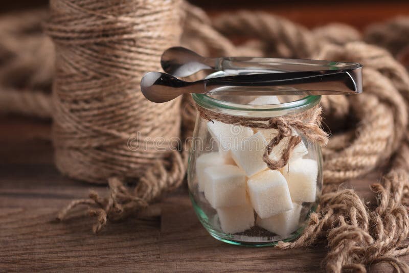 Concept: restaurant menus, healthy eating, homemade, gourmands, gluttony. Sugar in glass vintage jar on weathered wooden table. Concept: restaurant menus, healthy eating, homemade, gourmands, gluttony. Sugar in glass vintage jar on weathered wooden table.