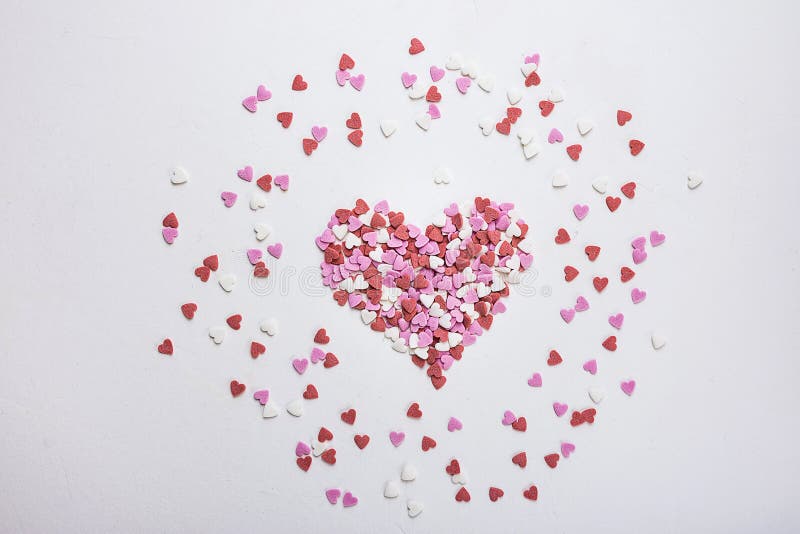 Sugar Sprinkles Candies in Heart Shape Scattered on White Background. Valentine Romance Birthday Charity Symbol.