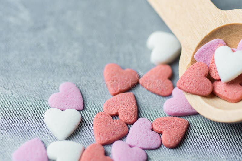 Sugar Sprinkles Candies Spilled blanco rosado colorido de la pequeña cuchara de madera en Grey Background valentines fotografía de archivo Sugar Sprinkles Candies Spilled blanco rosado colorido de la pequeña cuchara de madera en Grey Background valentines fotografía de archivo