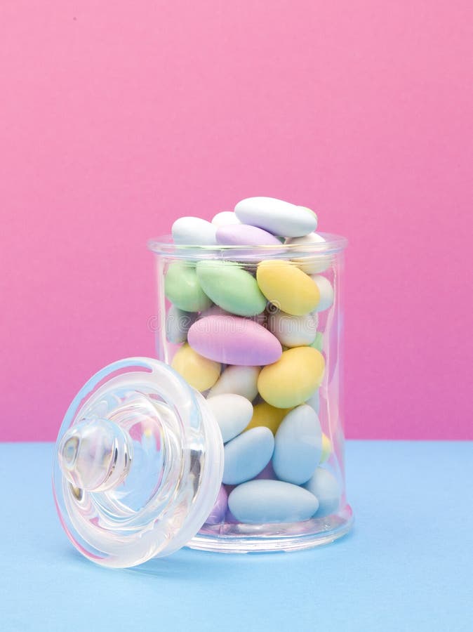 Suikergoed Met een laag bedekte Amandelen op een Roze en Blauwe Achtergrond stock foto Suikergoed Met een laag bedekte Amandelen op een Roze en Blauwe Achtergrond stock foto