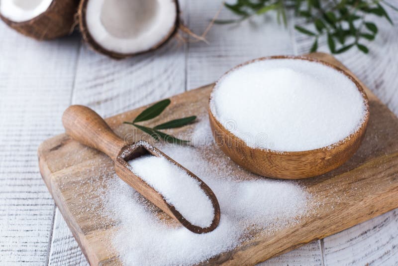 Sugar substitute in a wooden bowl on a background of coconut. Natural sweetener. Stevia, erythritol. High quality photo. Sugar substitute in a wooden bowl on a background of coconut. Natural sweetener. Stevia, erythritol. High quality photo