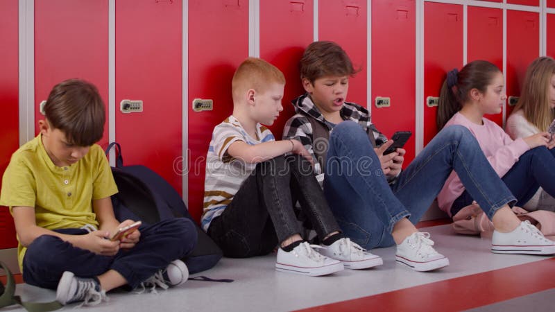 Suivi vidéo d'un groupe d'enfants utilisant un smartphone à l'école. banque de vidéos