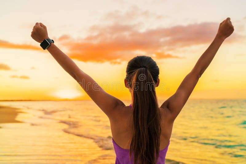 Sukces wolności smartwatch kobieta przy plażowym zmierzchem zdjęcia stock Sukces wolności smartwatch kobieta przy plażowym zmierzchem zdjęcia stock