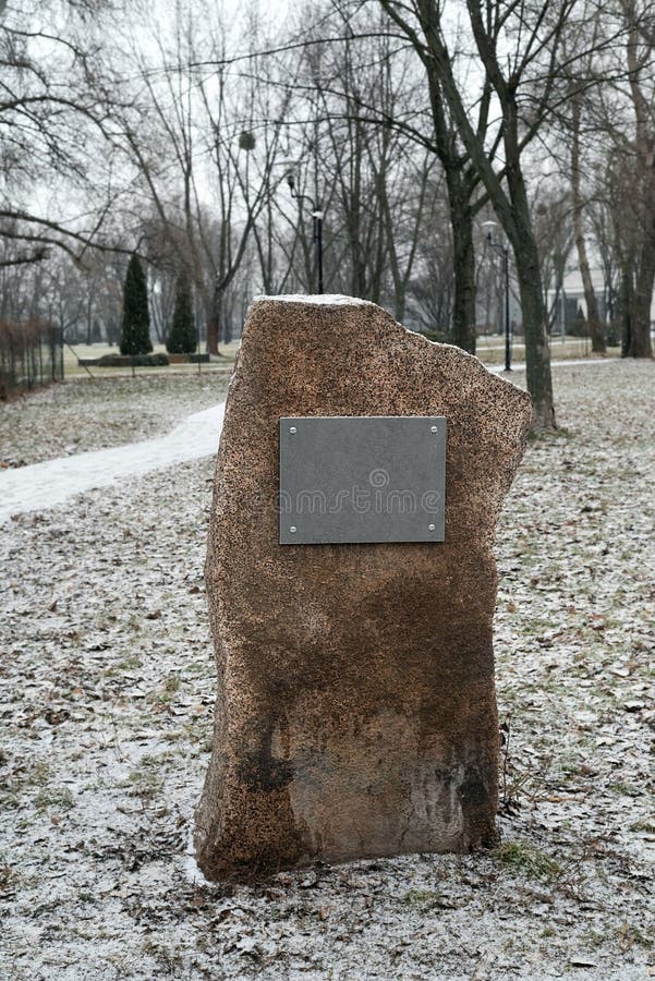 Sullo sfondo di un parco invernale un'immagine sfocata di una pietra con un segno di scrittura di testo fotografia stock