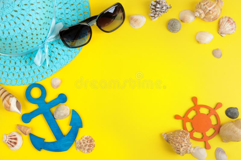 summer accessories with sun glasses, a hat and shells, on a bright yellow background. top view. space for text