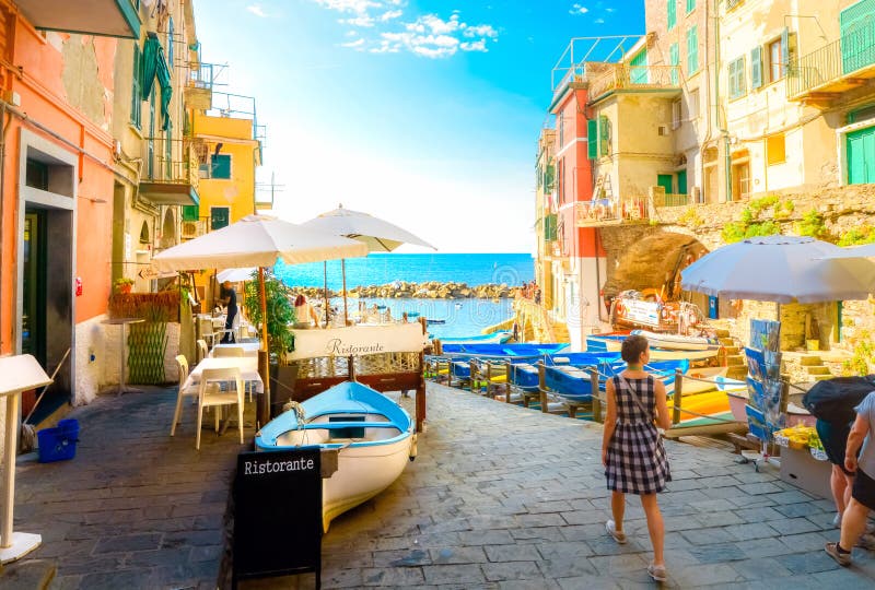 Summer day as tourists walk towards the boat launch of Riomaggiore, Italy, on the Cinque Terre. stock photo Summer day as tourists walk towards the boat launch of Riomaggiore, Italy, on the Cinque Terre. stock photo