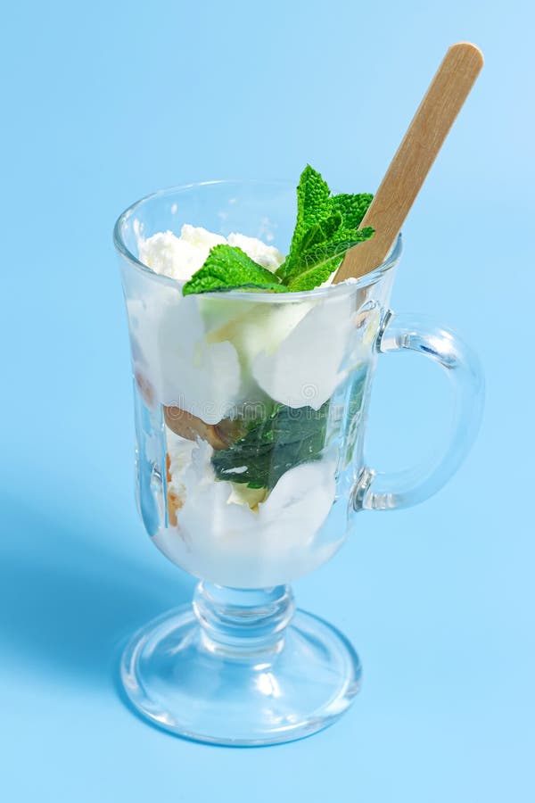 Summer Dessert. Ce Cream with Fruit and Mint Leaves in Glass on a Blue