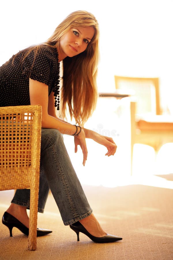 Beautiful young woman sitting in chair. Lovely european female stock images, royalty-free photos and pictures