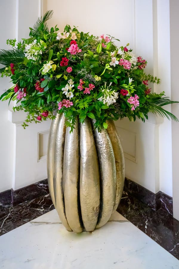 Summer flowers in arrangement, luxury bouquet with beautiful blooms, leafs in tall golden vase