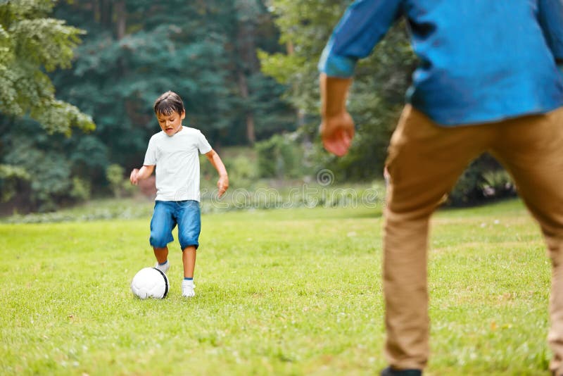 Summer football. Dad and son playing soccer.