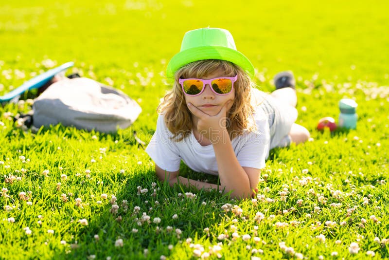 Summer holiday with children. Kids relaxation. Child laying in grass in the park. Summer holiday activitie. Kid boy are royalty free stock photos