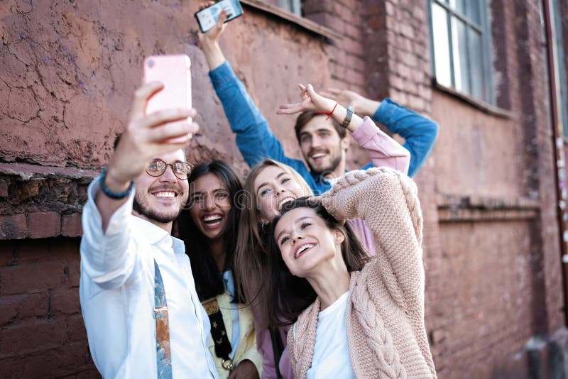 party, technology, nightlife and people concept - smiling friends with  smartphone taking selfie in club. Stock Photo