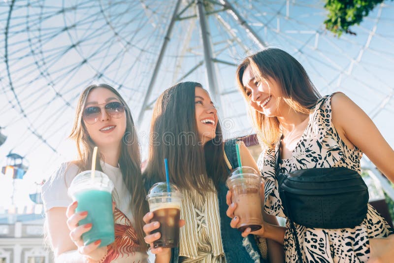 Summer lifestyle portrait multiracial women enjoy nice day, holding glasses of milkshakes. Happy friends inin front of royalty free stock images Summer lifestyle portrait multiracial women enjoy nice day, holding glasses of milkshakes. Happy friends inin front of royalty free stock images