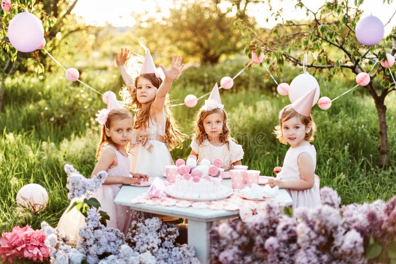 Summer outdoor kids birthday party. Group of happy Children celebrating birthday in park.