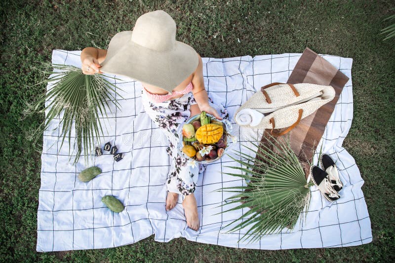 Summer picnic, girl with a plate of fruit. Cosy, outing.