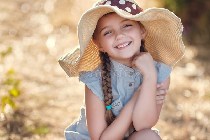 Summer portrait of a little girl in a big hat